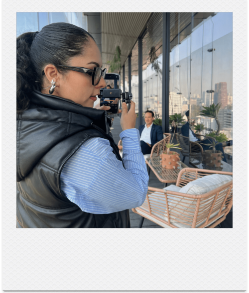 Integrante de Ayrée filmando con cámara profesional en una terraza